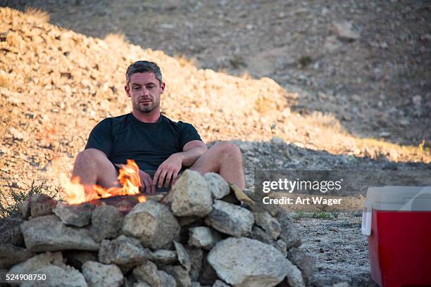 man sitting by the campfire - campfire art stock pictures, royalty-free photos & images