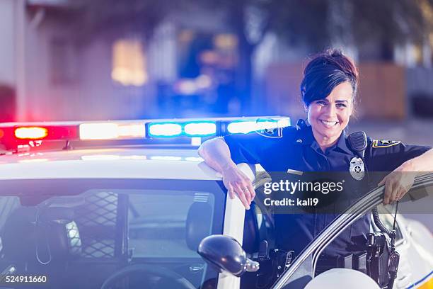 weibliche polizist stehen neben patrouille auto - police uniform stock-fotos und bilder