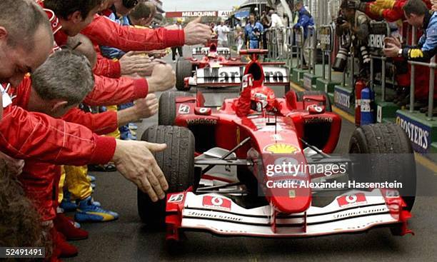 Motorsport / Formel 1: GP von Australien 2004, Melbourne; Michael SCHUMACHER / Ferrari, Sieger des GP, kommt nach dem Rennen in die Box und wird von...