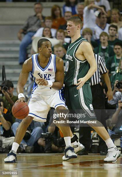 Shelden Williams of the Duke Blue Devils handles the ball under pressure from Paul Davis of the Michigan State Spartans during the 2005 NCAA division...