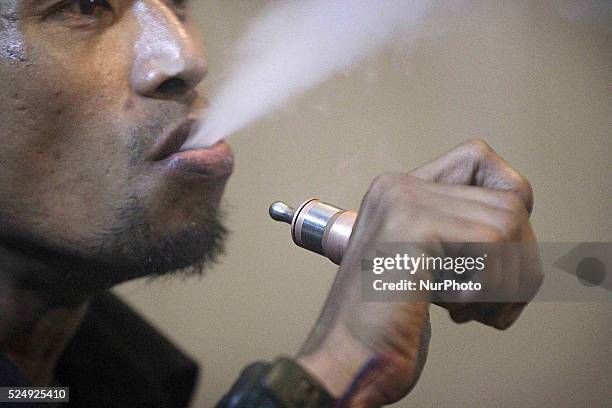 Remaja Indonesia menghembuskan asap dari Rokok Elektrik seperti dilihat di Medan, Sumatera Utara, Indonesia pada 5 Desember 2014. Rokok elektrik...