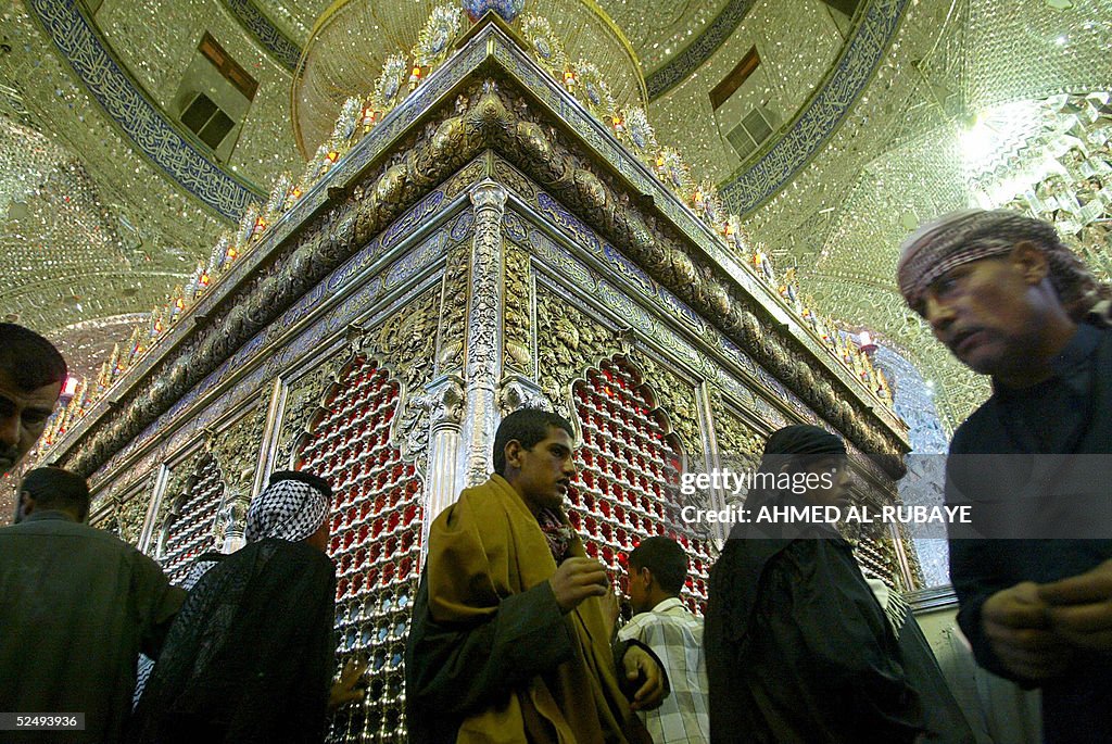 Iraqi Shiite muslim men pray inside the