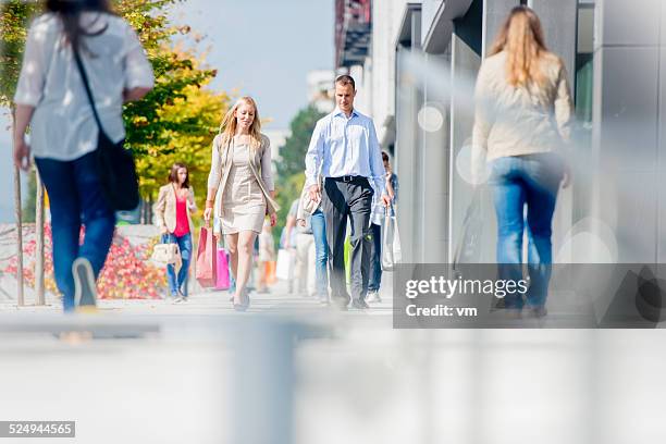 couple sur une rue de ville bondées après une journée de shopping - zone piétonnière photos et images de collection