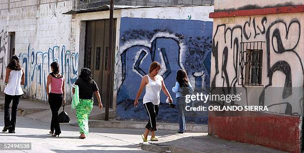 Women walk in "Ciudad del Sol" a place dominated by the Mara Salvatrucha in the south of Guatemala City, 26 March 2005. Violence from street gangs,...