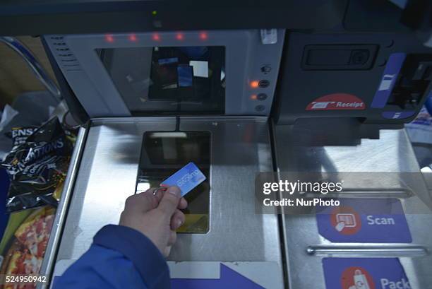 Tesco supermarket shopper scanning their clubcard at a self-service checkout, on Monday 27th April 2015. -- The Tesco supermarket chain is an...