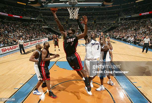 Dwyane Wade of the Miami Heat takes the ball to the basket against Kwame Brown of the Washington Wizards during the game on December 15, 2004 at the...