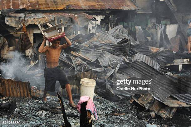 Philippines - Residents scavenge what's left of their house after a fire broke out, Wednesday morning and razed around 60 houses in a neighborhood in...