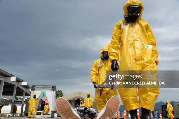 Brazilian armed forces' anti terrorist personnel in NBC protective suits transport a "victim of a terrorist attack " during a drill ahead of the...