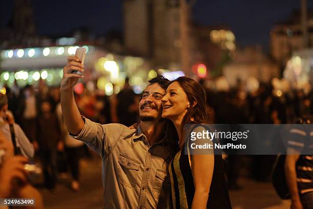 Turkish couple takes a photo of themselves with the Turkish policemen in background at Taksim square during a protest against the mining disaster in...