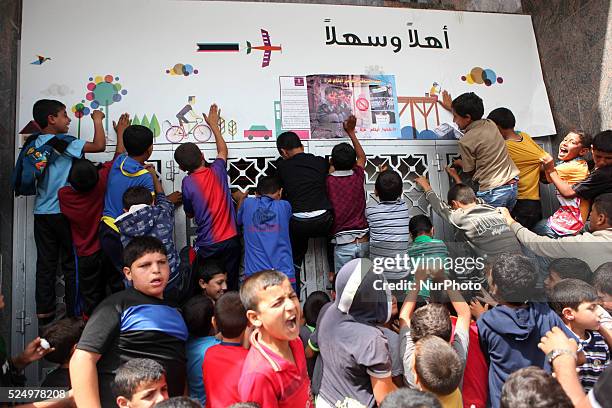 Palestinian relative of orphans and disabled hold banners during a protest against Palestine Bank policy on the closure of the accounts of charities...