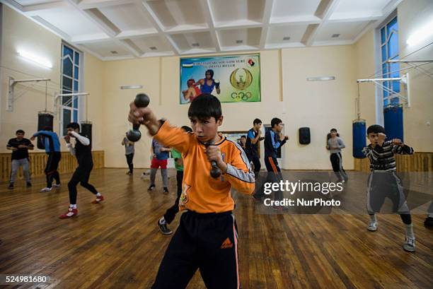 Younger students of High school of sport art in boxing train with dumbbells, Samarkand, Uzbekistan on 8 november 2104. High school of sport art in...