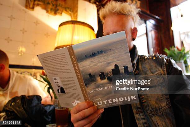 Man on April 30, 2015 in Leiden, Netherlands, is seen the recently released book by Dutch author Joris Luyendijk who spent three years interviewing...