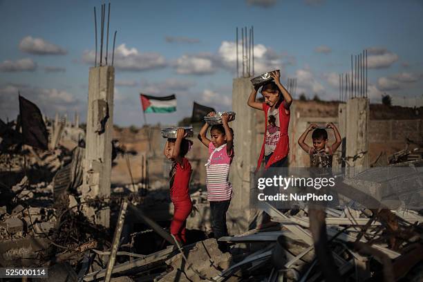 Palestinian girls collect metal pans from buildings destroyed during the 50-day conflict between Hamas militants and Israel, in Shejaiya...