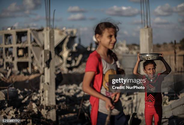 Palestinian girls collect metal pans from buildings destroyed during the 50-day conflict between Hamas militants and Israel, in Shejaiya...