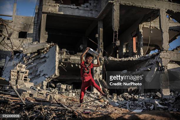 Palestinian girls collect metal pans from buildings destroyed during the 50-day conflict between Hamas militants and Israel, in Shejaiya...