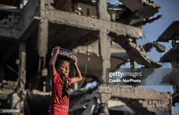 Palestinian girls collect metal pans from buildings destroyed during the 50-day conflict between Hamas militants and Israel, in Shejaiya...