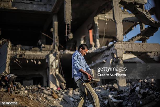 Palestinian men collect concrete blocks from building destroyed during the 50-day conflict between Hamas militants and Israel, in Shejaiya...