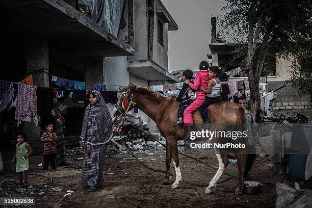 Palestinian children play near a building destroyed during the 50-day conflict between Hamas militants and Israel, in Shejaiya neighbourhood in the...