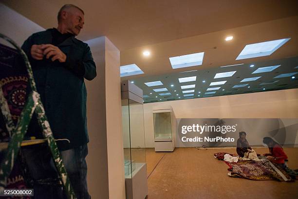 Electrician sets light in the exhibition hall of suzani work, traditional Uzbek embroidery textile, during preparation to the exhibition in new...