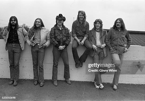 Southern, Country and Roots Rock, Marshall Tucker Band pose for photo outside concert hall backstage door 1973 in San Francisco, California. .