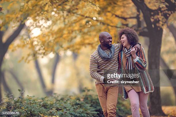happy african american couple walking in autumn park and laughing. - young couple holding hands stock pictures, royalty-free photos & images