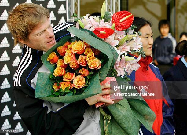 Fussball: Nationalmannschaft Deutschland 2004, Busan; Torwart Oliver KAHN kann seine erhaltenen Geschenke kaum festhalten 18.12.04.