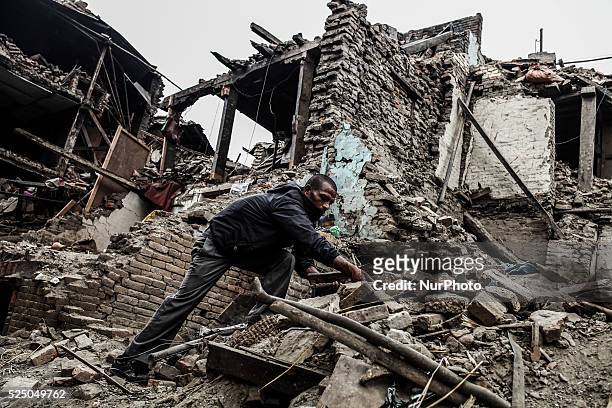 Man is collecting goods from debris of his house, Bhaktapur, Nepal May 9 2015.