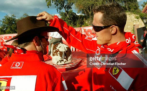 Motorsport / Formel 1: GP von Spanien 2004, Barcelona; Michael SCHUMACHER / Ferrari setzt seinem Teamkollegen Rubens BARRICHELLO einen Cowboyhut auf...