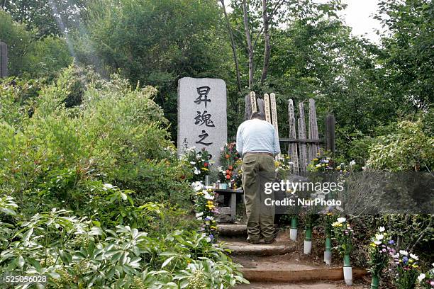 Relatives of the victims of the 1985 Japan Airlines jumbo jet crash pray in front of the victims' monument at Osutaka Ridge north of Tokyo, Japan,...