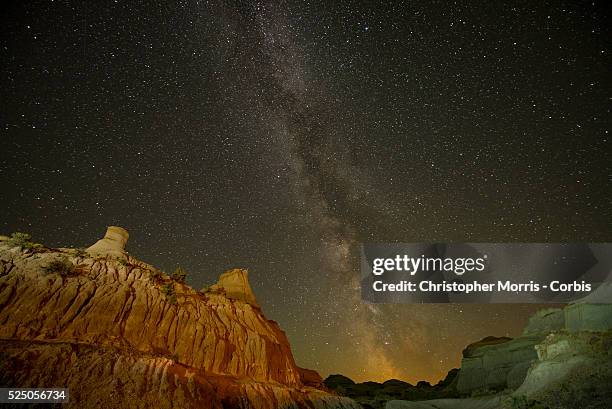 The Milky Way galaxy appears in the dark night sky over hoodoos in the Alberta Badlands at Dinosaur Provincial Park.