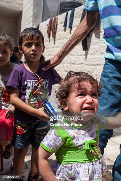Palestinian girl cries after hearing a near by explosion during the Eid Al Fitr celebrations at the Church of Saint Porphyrios in Gaza. Her brother,...