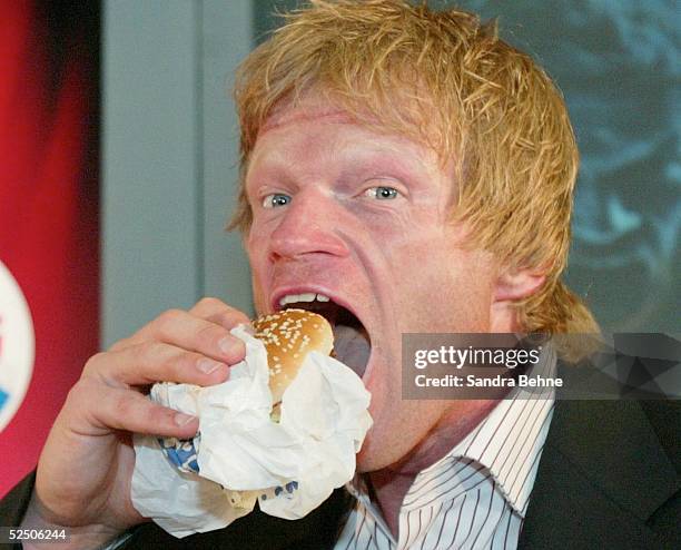 Fussball / Diverse: Muenchen; Bayerns Torwart Oliver Kahn zu Besuch im Burger King; Oliver KAHN laesst sich den Hot Chili Double schmecken 18.05.04.