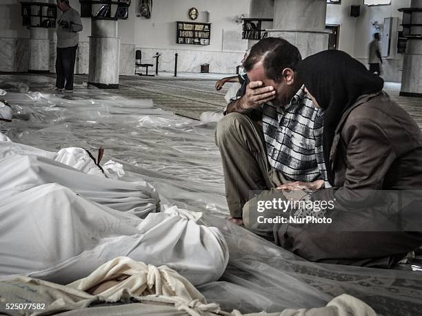 Mother and father weep over their child's body who was killed in a suspected chemical weapons attack on the Damascus suburb of Ghouta, in August 21,...