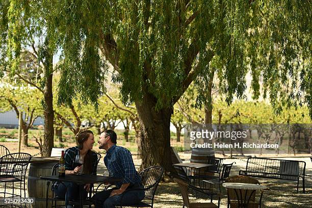 Katie Welch, left, and her boyfriend Chris Blastos, right, enjoy a bottle of red wine on the outdoor patio at Maison La Belle Vie winery on April 21,...