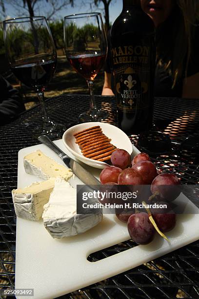 Plate of cheese, crackers and fruit go along with a bottle of wine on the patio at Maison La Belle Vie winery on April 21, 2016 in Palisade,...