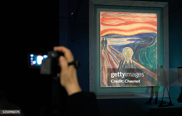 Visitor takes a picture of a painting The scream of Edvard Munch as part of the opening of the exhibition "Keys to a Passion" at the Louis Vuitton...