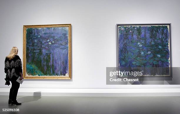 Visitor looks at paintings Blue water lilies and Water lilies of Claude Monet as part of the opening of the exhibition "Keys to a Passion" at the...