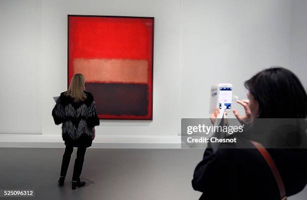 Visitor takes a picture of a painting Black, Ochre, Red Over Red of Mark Rothko as part of the opening of the exhibition "Keys to a Passion" at the...