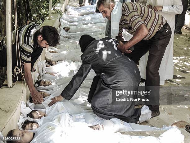 Mother and father weep over their child's body who was killed in a suspected chemical weapons attack on the Damascus suburb of Ghouta, in August 21,...