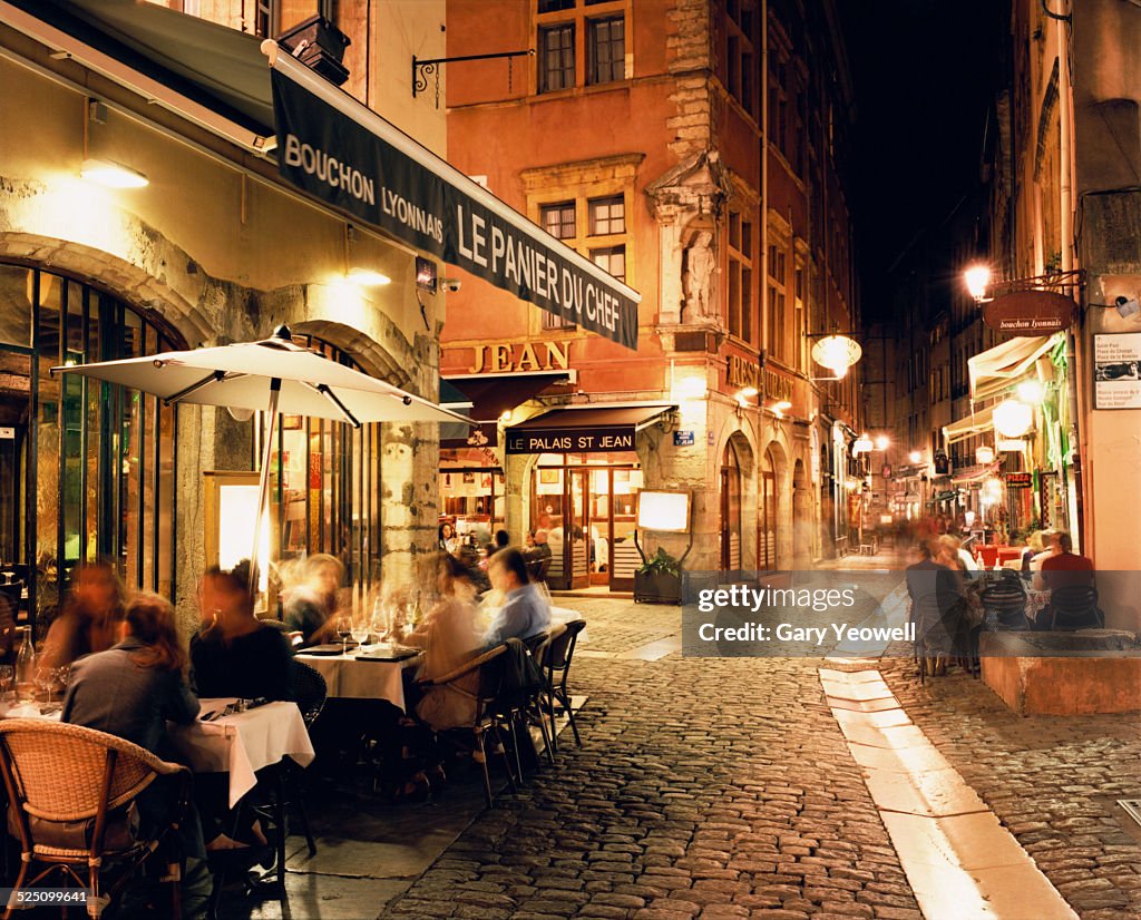 Lyon, People dining along cobbled street at night