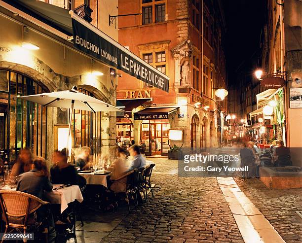 lyon, people dining along cobbled street at night - 里昂 法國 個照片及圖片檔