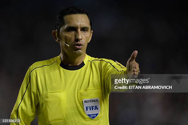 Paraguayan referee Julio Quintana gestures during the Copa Libertadores 2016 round before the quarterfinals first leg match between Argentina's...