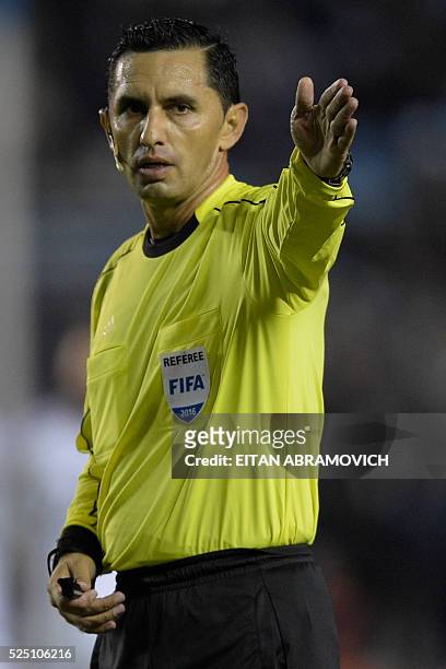 Paraguayan referee Julio Quintana gestures during the Copa Libertadores 2016 round before the quarterfinals first leg match between Argentina's...