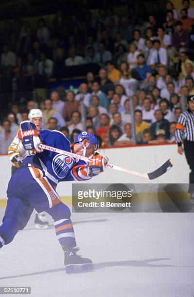 Canadian professional hockey player Wayne Gretzky of the Edmonton Oilers shoots the puck on the ice during game four of the Stanley Cup Championship...