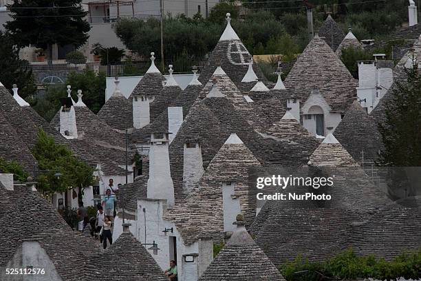 Tourist walk through Alberobello's streets on Aug. 5, 2014. Alberobello is a town in south east part of Italy in the Bari province, with its unique...