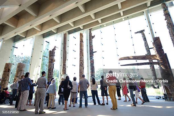 Visitors admire the totem pole carvings on display at the the University of British Columbia's museum of Anthropology, designed by architect Arthur...