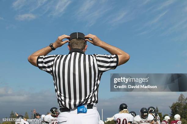 High school football referee adjusts his cap during a game between Sacred Heart Prep of Atherton, California, and Salesian High School of Richmond,...