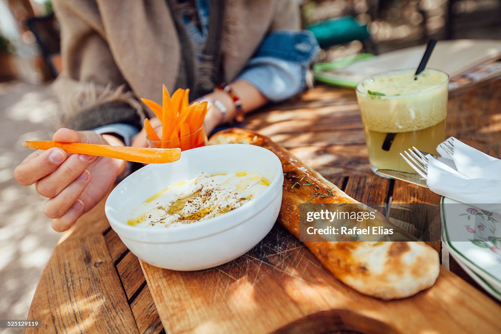 Woman eating hummus in terrace bar