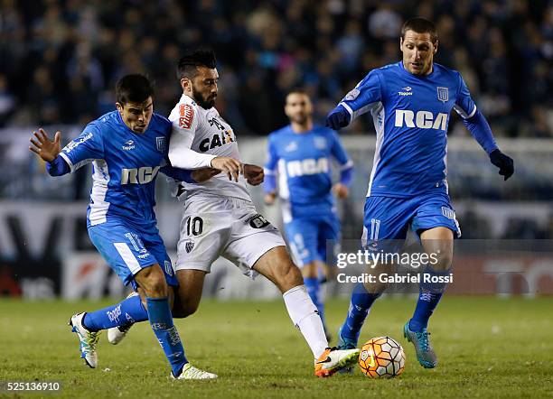 Jesus Datolo of Atletico Mineiro fights for the ball with Luciano Aued and Marcos Acu��a of Racing Club during a first leg match between Racing Club...