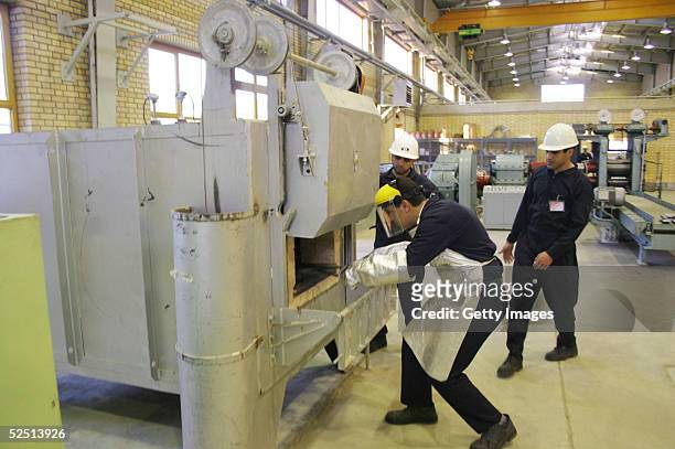 Iranian men work at the ZPP during the Iranian President Mohammad Khatami's visit to the uranium conversion facility producing unit March 30, 2005...